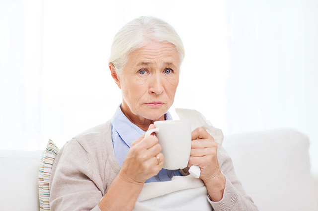 Image of an elderly lady relaxing with a hot drink